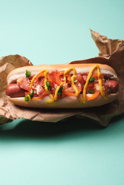 top view of yummy hot dog in paper on blue - 写真・画像