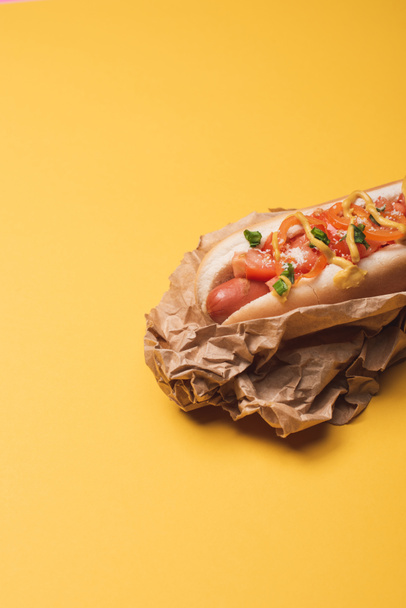 one delicious american hot dog in paper on yellow   - 写真・画像