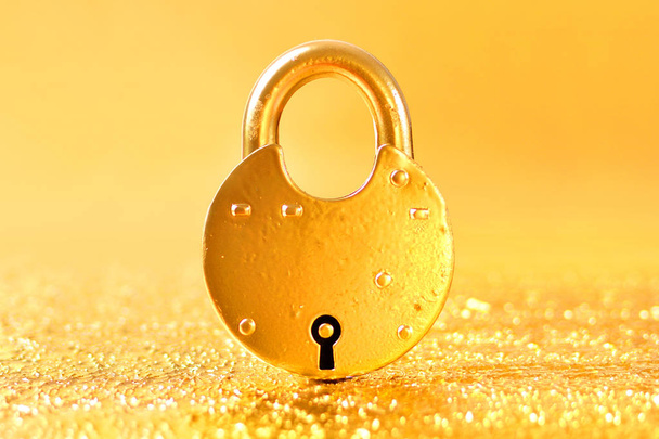 Way to Wealth concept with golden padlock on a gold background - 写真・画像