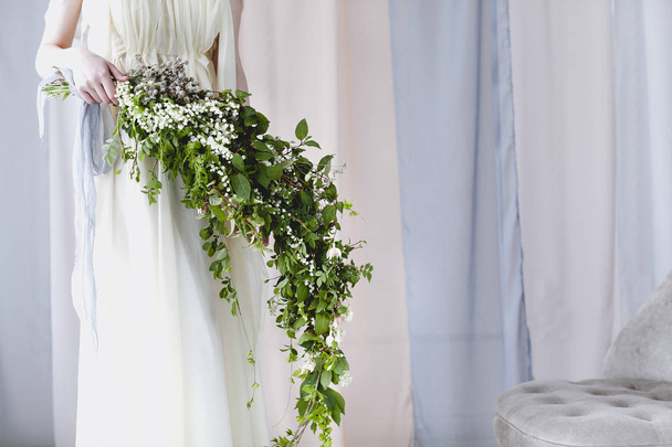 小さな白い花の珍しい花束と繊細なガウンで花嫁 - 写真・画像