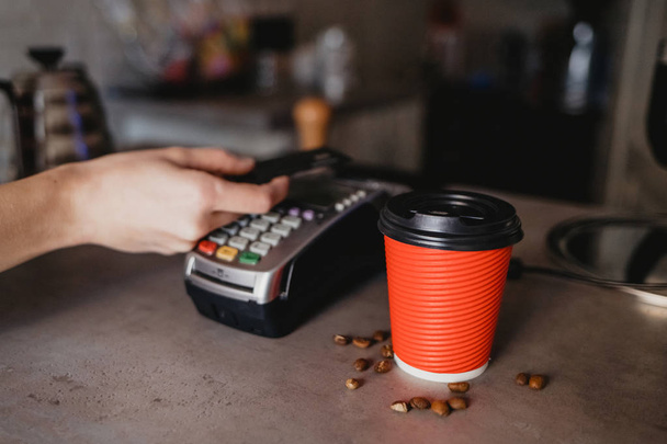 Customer pays for coffee with a credit card - Foto, afbeelding