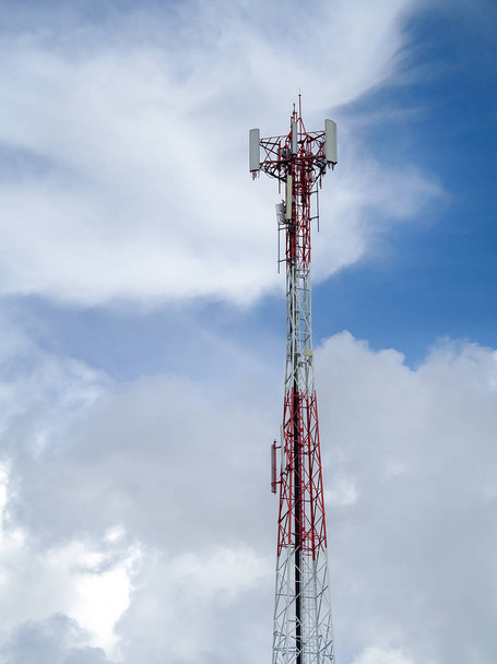 LTE, GSM, 2G, 3G, 4G, 5G πύργος κινητής επικοινωνίας. Τηλεπικοινωνιακός πύργος ενάντια στον γαλάζιο ουρανό με σύννεφα. - Φωτογραφία, εικόνα