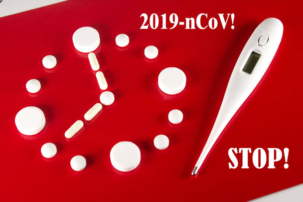 Óra készült fehér tabletta és hőmérő felirattal 2019- ncov, Stop piros háttér, felső nézet. 2019 Novel Coronavirus 2019-ncov koncepció. - Fotó, kép