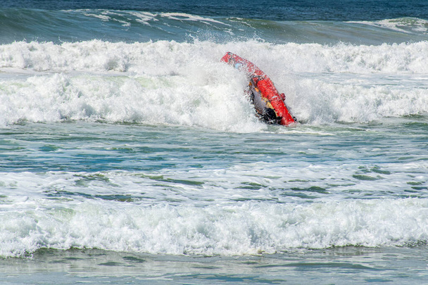 Szörf mentő mentőcsónakok fejjel lefelé a hullámok - Fotó, kép