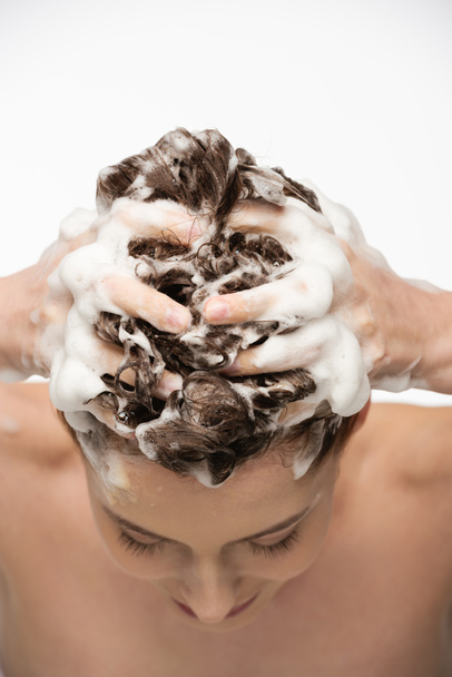 白いシャンプーで髪を洗う若い女性は - 写真・画像