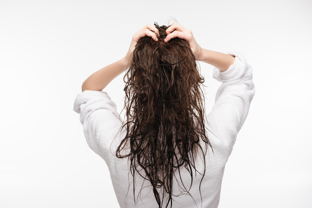 πίσω όψη της νεαρής γυναίκας αγγίζοντας καθαρά μακριά μαλλιά απομονώνονται σε λευκό - Φωτογραφία, εικόνα