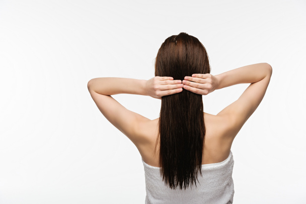 Rückseite der jungen Frau berührt saubere glatte Haare isoliert auf weiß - Foto, Bild