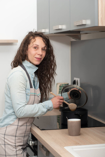 young woman with long hair is in the kitchen - 写真・画像