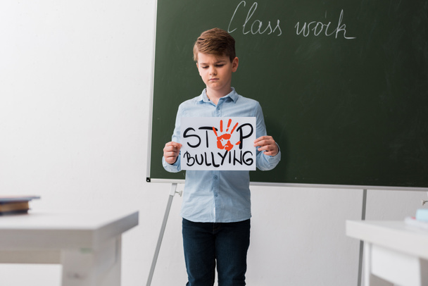 enfoque selectivo de la pancarta de colegiales con letras de stop bullying
  - Foto, Imagen