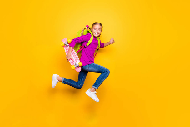 Full length body size view of her she nice attractive glad purposeful cheerful cheery girl jumping running carrying longboard having fun isolated on bright vivid shine vibrant yellow color background - Foto, Bild