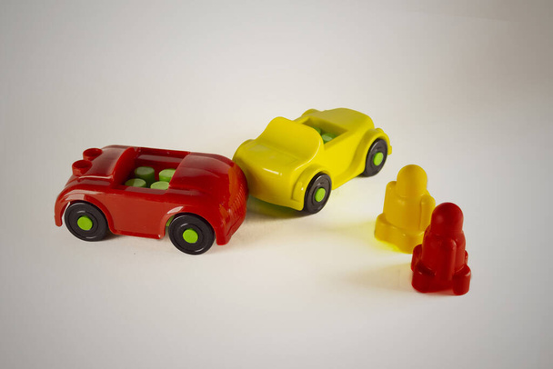 Dos hombres desesperados en coches de juguete involucrados en accidentes, imagen conceptual con miniaturas y figuritas sobre fondo blanco. Primer plano de una colisión de dos coches de juguete sobre un fondo blanco
. - Foto, imagen
