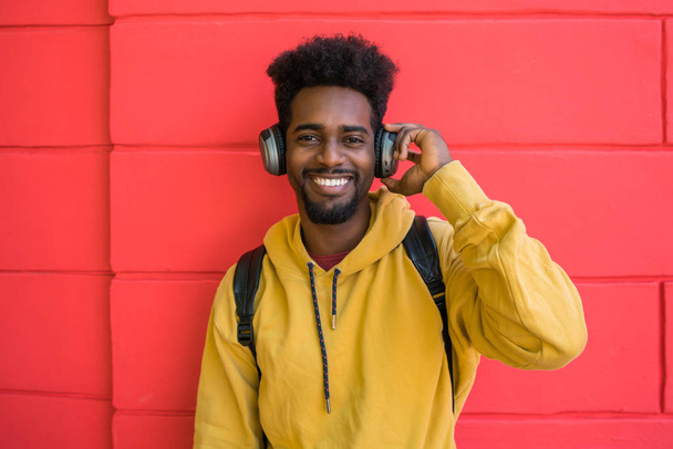 Young afro man listening to music with headphones. - Fotó, kép