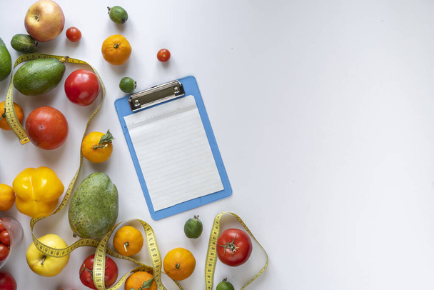 un plano de la hoja de papel en blanco maqueta para la receta plat dieta, fruta fresca cruda en la mesa
 - Foto, Imagen
