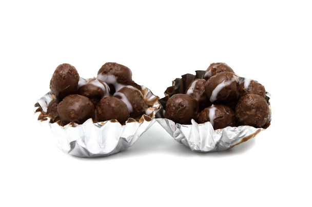 Mini bolas de chocolate dentro de la taza sobre fondo blanco
. - Foto, Imagen