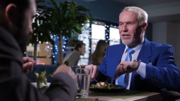 Portret van een man die geniet van eten en praten - Video