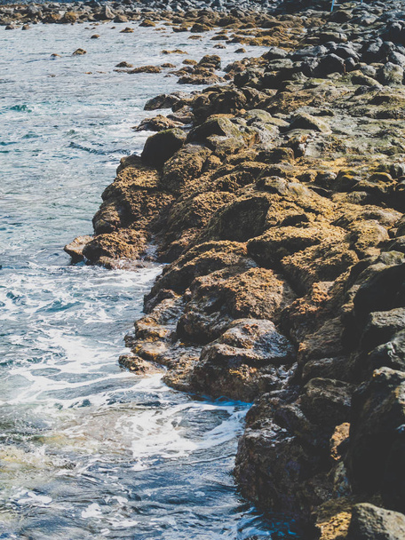 Imagem tonificada da costa rochosa oceânica. Clifs afiados e superfície calma do oceano em dia ensolarado brilhante
 - Foto, Imagem