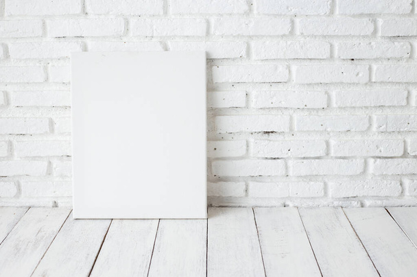 Empty white canvas frame on a wooden table - Foto, imagen