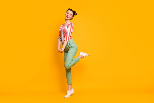 Full length profile photo of pretty lady enjoy warm spring day traveling abroad wear casual red white shirt green pants footwear isolated bright yellow color background - Valokuva, kuva