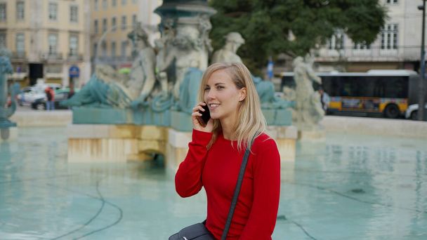 Young attractive woman relaxes at a fountain in the city of Lisbon - CITY OF LISBON, PORTUGAL - OCTOBER 15, 2019 - Фото, изображение