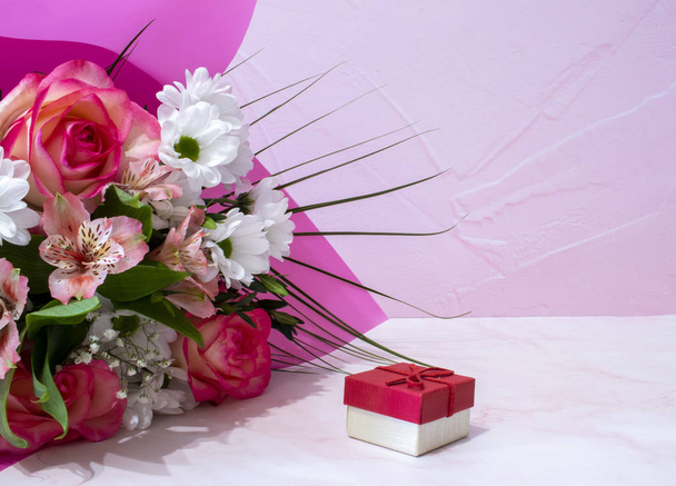 Romantické pozadí s kyticí barevných květin a dárkové krabice na růžové. Boční pohled s místem pro kopírování. Den matek, Dámské den pozadí. - Fotografie, Obrázek