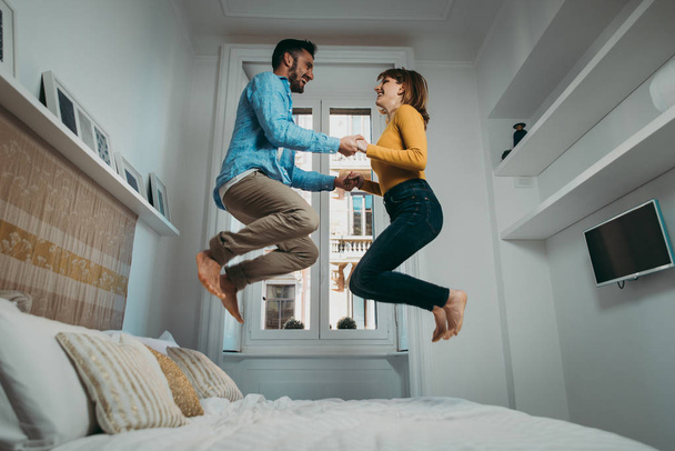 Young couple spending time together at home. Man and woman danci - Foto, afbeelding