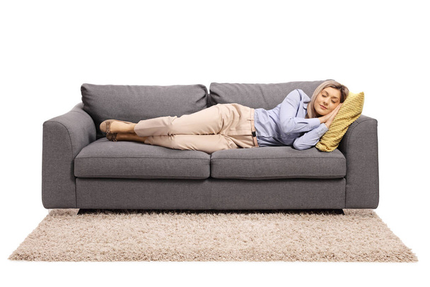 Young woman sleeping on a sofa - Fotó, kép