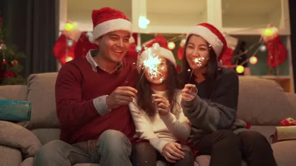 Slow motion video shooting of a happy family living all together of father Mother and daughter playing fun fireworks on Christmas day. - Záběry, video