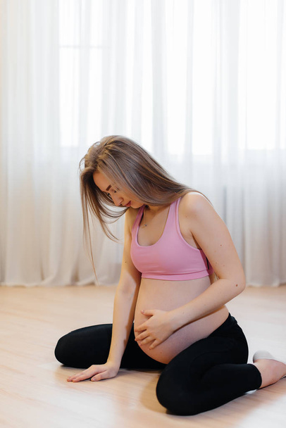 The pregnant girl felt a strong pain in her stomach. Pregnant - Photo, Image