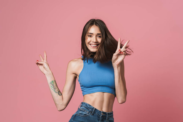 Image of young brunette woman smiling and showing peace fingers - Foto, Imagem