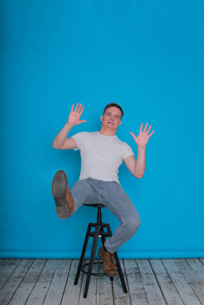 moderní portrét emotivní stylový elegantní mladý muž v bílém tričku na jasně modrém pozadí - Fotografie, Obrázek