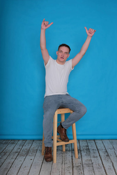 modern portrait emotional classy stylish young man in white t-shirt on bright blue background - Fotó, kép