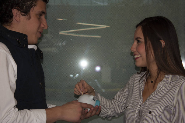 Usmívající se žena se dívá do očí muže, který dává mince selatovi, aby ušetřil - Fotografie, Obrázek