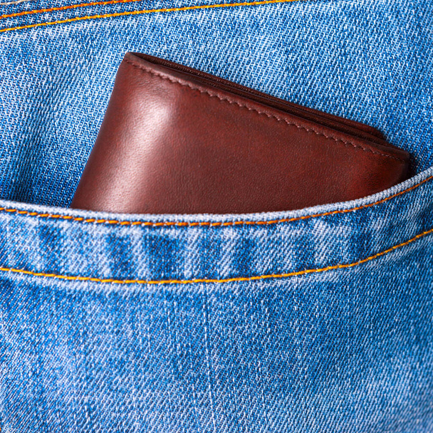 Крупним планом коричневий шкіряний гаманець, що виглядає з блакитних джинсів назад р
 - Фото, зображення