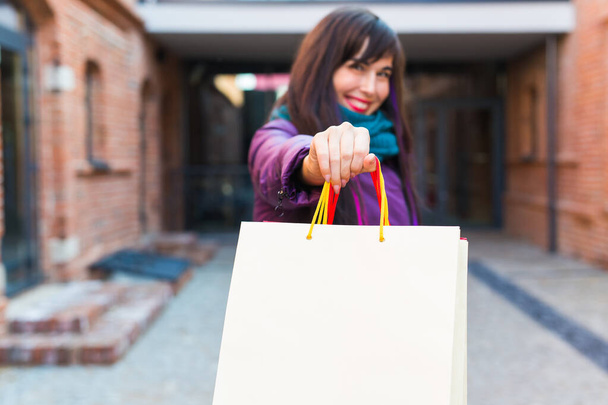 Shopping, consumatore e concetto di vendita - Bella donna che tiene molte borse della spesa in una strada della città, primo piano
 - Foto, immagini