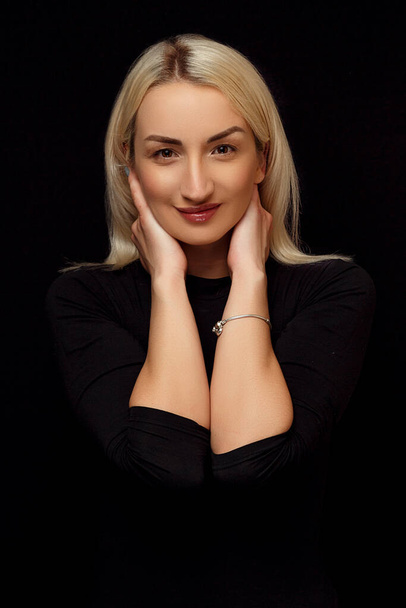 Porträt einer jungen kaukasischen schönen blonden Frau. ihre Hände auf ihrem Gesicht - Foto, Bild