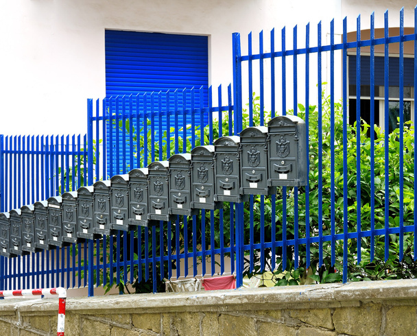 row of gray metal mailboxes near railing - Photo, Image