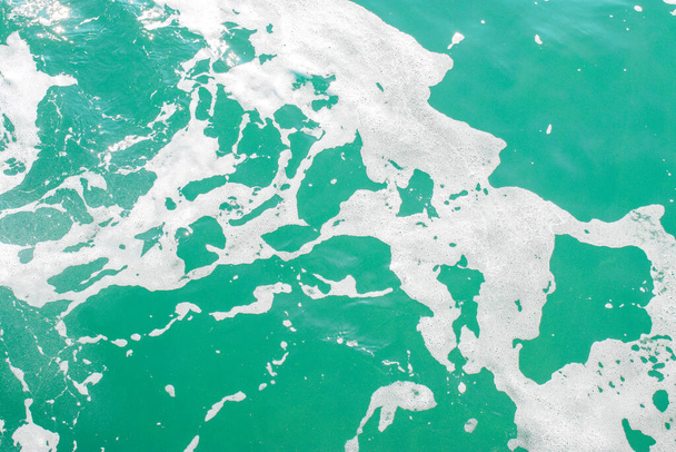 Eau de mer turquoise avec mousse. Fond marin abstrait. Ondes océaniques en gros plan. Concentration douce
. - Photo, image