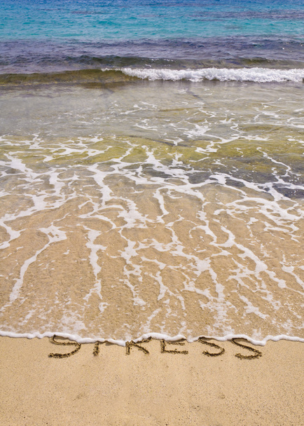 λέξεις στρες γραμμένο στην άμμο, συμπαρασύρονται από τα κύματα - Φωτογραφία, εικόνα