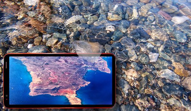 Quallen treiben im Wasser über Steinen aus dem Schwarzen Meer und Handy - Foto, Bild