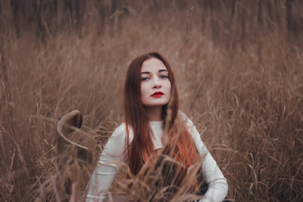 Portrait of a beautiful redhead girl in a field - Photo, image