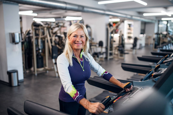 A senior woman in gym doing cardio work out exercise. - Fotoğraf, Görsel