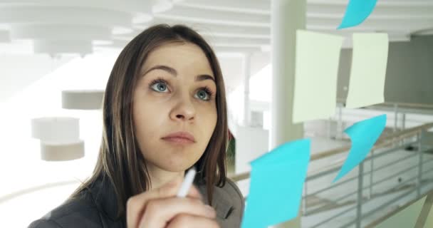 Female team create brainstorming ideas on sticky notes at modern glass office - Filmati, video