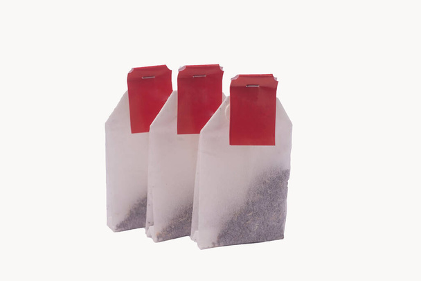 lähikuva teepussit punaisella etiketillä eristetty valkoisella taustalla
 - Valokuva, kuva