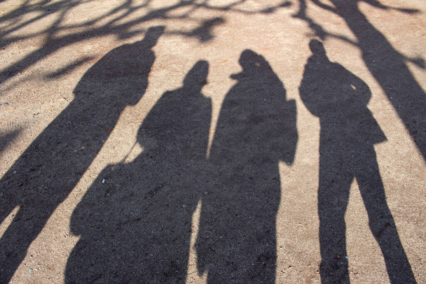 Sombras de gente y tees en la grava
 - Foto, imagen