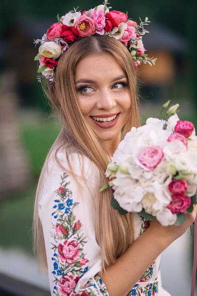 closeup of the bride in an embroidered dress with a wedding bouq - Fotografie, Obrázek