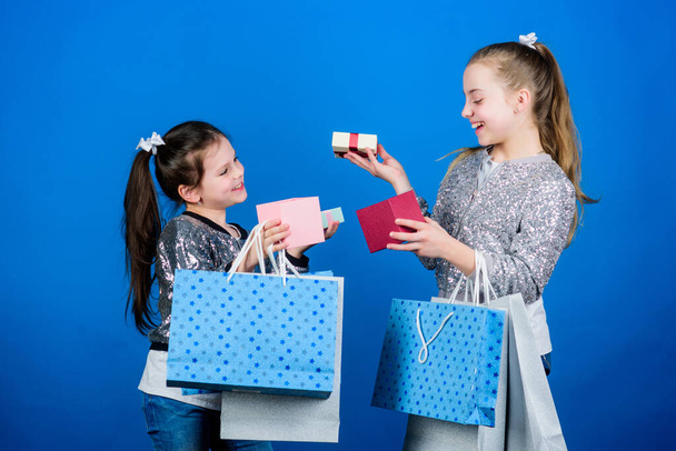 Girls sisters friends with shopping bags blue background. Every product delivered to you. Shopping and purchase. Black friday. Sale and discount. Children bunch packages. Shopping day. Kids fashion - Photo, image