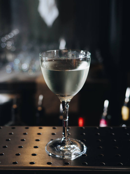 Clear alcohol cocktail in glass on bar counter - Fotoğraf, Görsel