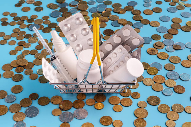 cesta de compras comprimidos medicinais cheios, comprimidos e frasco de spray em moedas espalhadas
 - Foto, Imagem