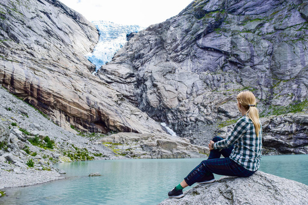 Młoda kobieta w pobliżu lodowca Briksdalsbren. Norwegia. - Zdjęcie, obraz