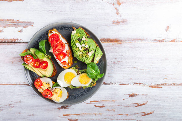 Sweet potato toasts with avocado, eggs, tomatoes and sesame seeds - Photo, Image